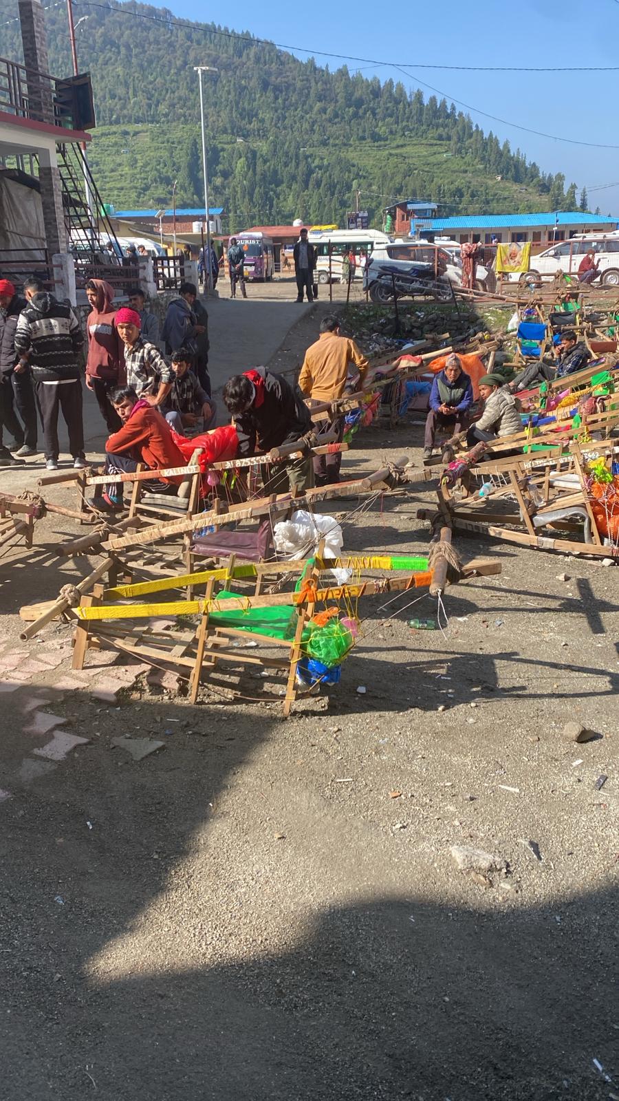 Devotees standing in front of the Kedarnath temple with helicopters in the background